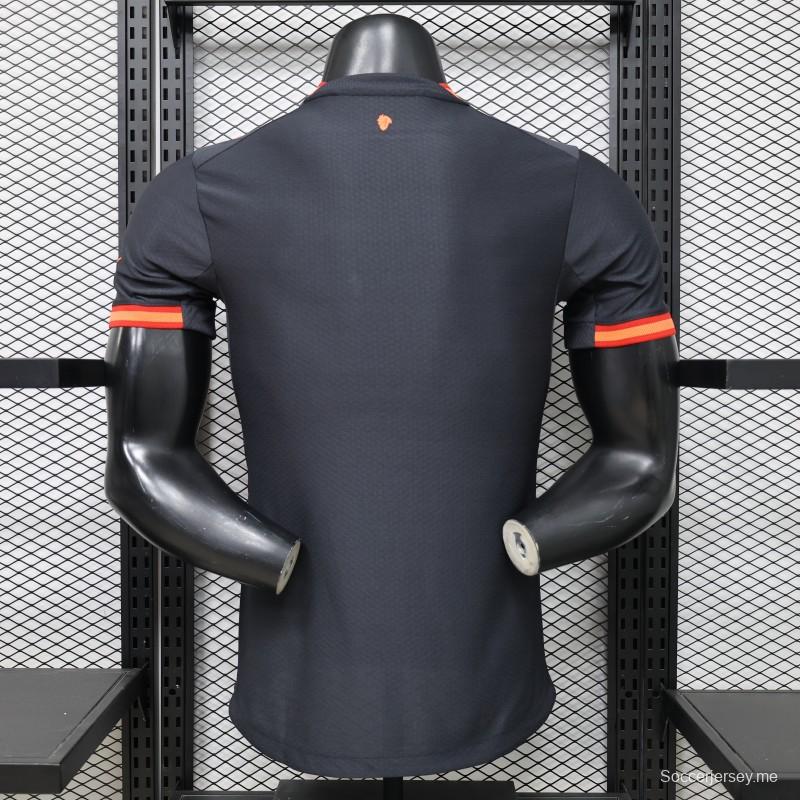 قميص اللاعب نسخة 26/27 لميلان (الزي الخارجي) باللون الأزرق الداكن مع لمسات باللون البرتقالي النحاسي