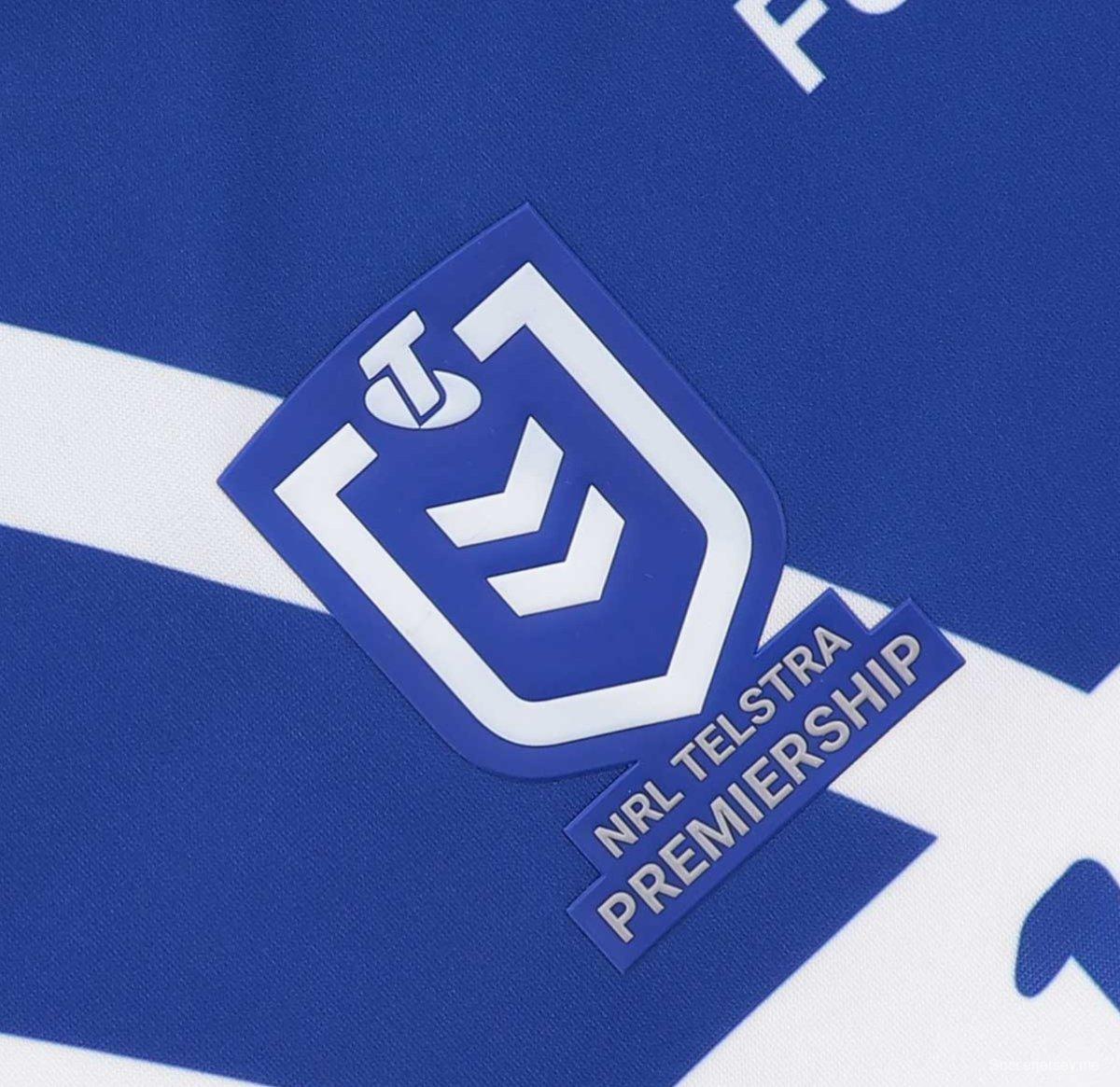 25/26 قميص كانتربري-بانكستاون بولدوغز أبيض مع أكتاف زرقاء خارج الملعب